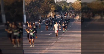 Corredores se preparando para a largada da Corrida Top VG 2025 em Várzea Grande, com o sol nascendo ao fundo. Créditos: Prefeitura de Várzea Grande / Instagram.