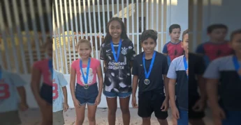 Crianças pulando em sacos em uma corrida divertida, com uma mulher observando. Créditos: Cultura Marcelândia / Instagram.