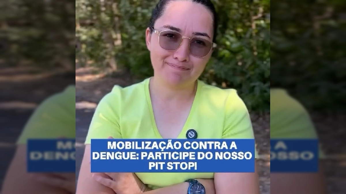 Mulher com óculos e camiseta verde claro, com distintivo da prefeitura, sorrindo e gesticulando em um ambiente arborizado, representando a mobilização da prefeitura de Guarantã do Norte contra a dengue. Créditos: Prefeitura Municipal de Guarantã do Norte / Instagram.