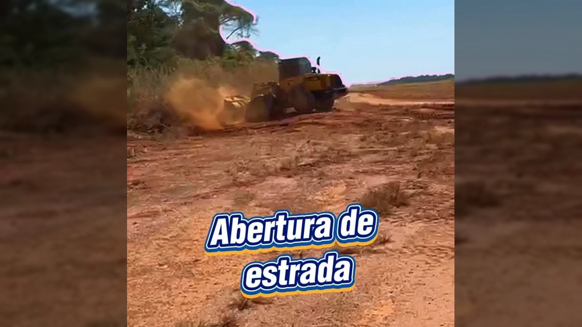 Máquina pesada amarela operando em uma estrada de terra vermelha, desmatando a lateral e levantando poeira. Créditos: Prefeitura de Gaúcha do Norte / Instagram.