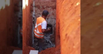 Imagem de máquina retroescavadeira e trabalhadores em obra de drenagem na Avenida Brasil, Vila Rica.