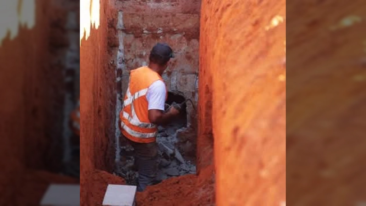 Imagem de máquina retroescavadeira e trabalhadores em obra de drenagem na Avenida Brasil, Vila Rica.