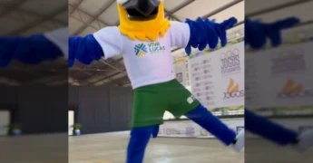 Mascote do evento e jovens atletas no pódio com medalhas e troféus em Lucas do Rio Verde. Créditos: Instagram / vivalucasesportelazer.