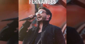 Matheus Fernandes se apresentando em um palco de festival na Praia do Cortado em Sinop, com muitas pessoas na praia e na água. Créditos: Festeja Sinop / Instagram
