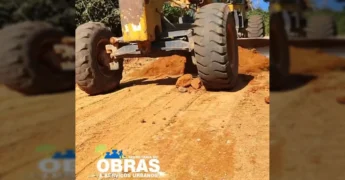 Motoniveladora amarela trabalhando na estrada de terra da Linha 16 Eletrônica, com terraplanagem sendo feita e pedras removidas. Créditos: Prefeitura de Colniza / Instagram.