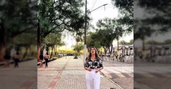 Kelly Paula Freitas, influenciadora digital, anuncia o FIP 2025 em Cáceres, Mato Grosso, sobre um fundo de pôr do sol no rio.