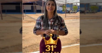 Imagem de uma mulher em frente ao ginásio, convidando para o Baile da Rainha do Café. Créditos: prefeitura_novabandeirantes / Instagram.