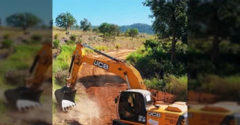 Máquina escavadeira JCB trabalhando em estrada de terra vermelha, com pilhas de terra e pedras ao lado. Crédito: Governo de Vila Rica-MT / Instagram