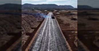 Imagem aérea de máquina aplicando asfalto em rua no Residencial Carvalho, Barra do Garças. Crédito: Prefeitura de Barra do Garças / Instagram.