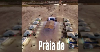 Vista aérea da Praia Luciara com tendas brancas iluminadas e palco montado para evento noturno. Créditos: Prefeitura Municipal de Luciara / Instagram