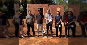 Grupo de pessoas, incluindo o prefeito Alexandre Russi, em frente a uma obra de casa em Juscimeira, anunciando a retomada da construção. Créditos: Prefeitura de Juscimeira / Instagram