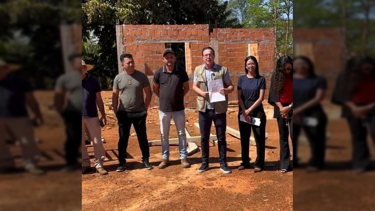 Grupo de pessoas, incluindo o prefeito Alexandre Russi, em frente a uma obra de casa em Juscimeira, anunciando a retomada da construção. Créditos: Prefeitura de Juscimeira / Instagram