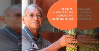 Homem sorrindo segurando um abacaxi, com logo da FALM e Amaggi ao fundo. Crédito: sigafalm