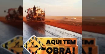Caminhão aplicando asfalto em rodovia de terra vermelha em Querência, Mato Grosso. Créditos: Prefeitura de Querência / Instagram.