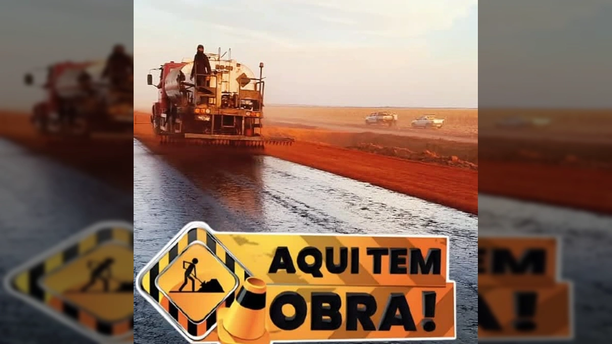 Caminhão aplicando asfalto em rodovia de terra vermelha em Querência, Mato Grosso. Créditos: Prefeitura de Querência / Instagram.