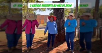 Imagem de três servidores da Prefeitura de Guiratinga em celebração pelo salário de julho, com chapéus de palha e sorrisos. Crédito: @prefeituraguiratinga.