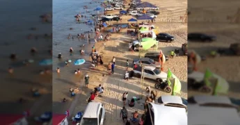 Vista aérea da praia de Luciara durante a temporada de verão com muitas pessoas, carros e tendas. Créditos: djgoogleplay / Instagram