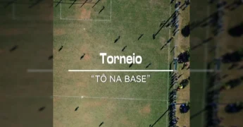 Jovens jogadores de futebol em ação em campo gramado com torcedores ao fundo, durante o torneio 'Tô na Base' em Nova Ubiratã. Créditos: Prefeitura de Nova Ubiratã / Instagram.