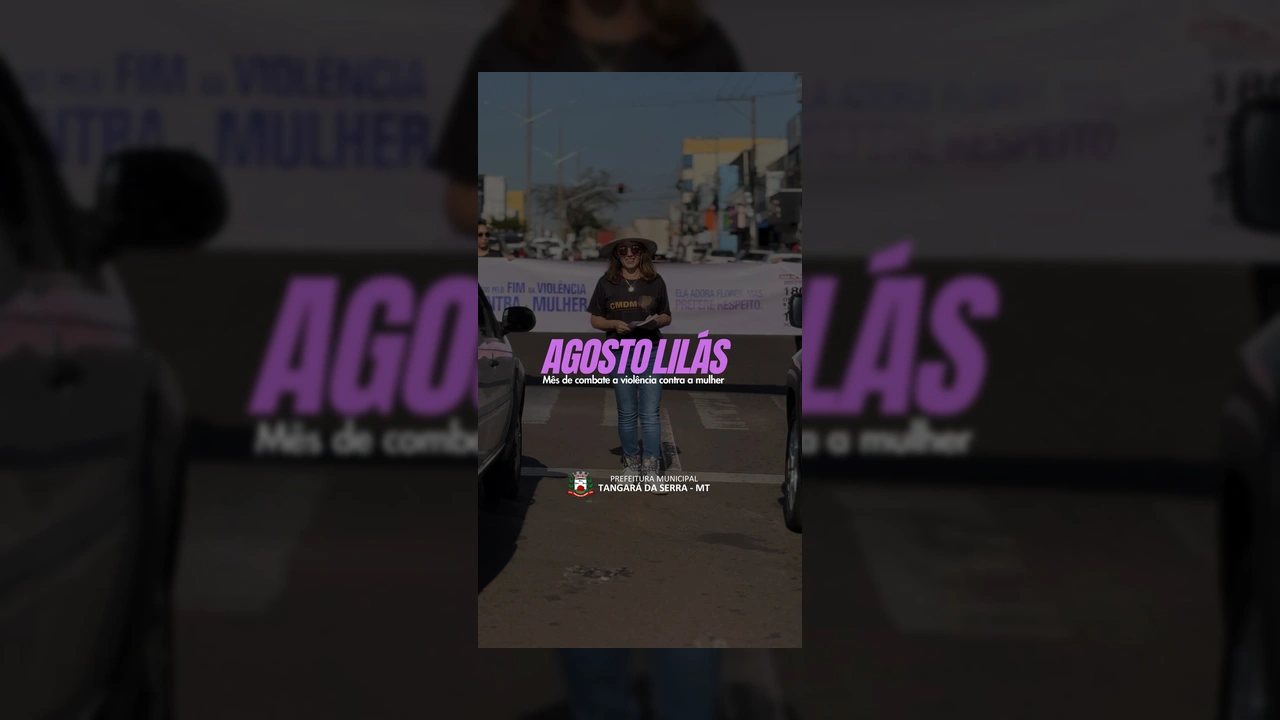 Mulher de chapéu e óculos escuros, Silvana Ló Masson, falando em frente a um banner do Agosto Lilás em Tangará da Serra. Créditos: Prefeitura de Tangará da Serra / Instagram.