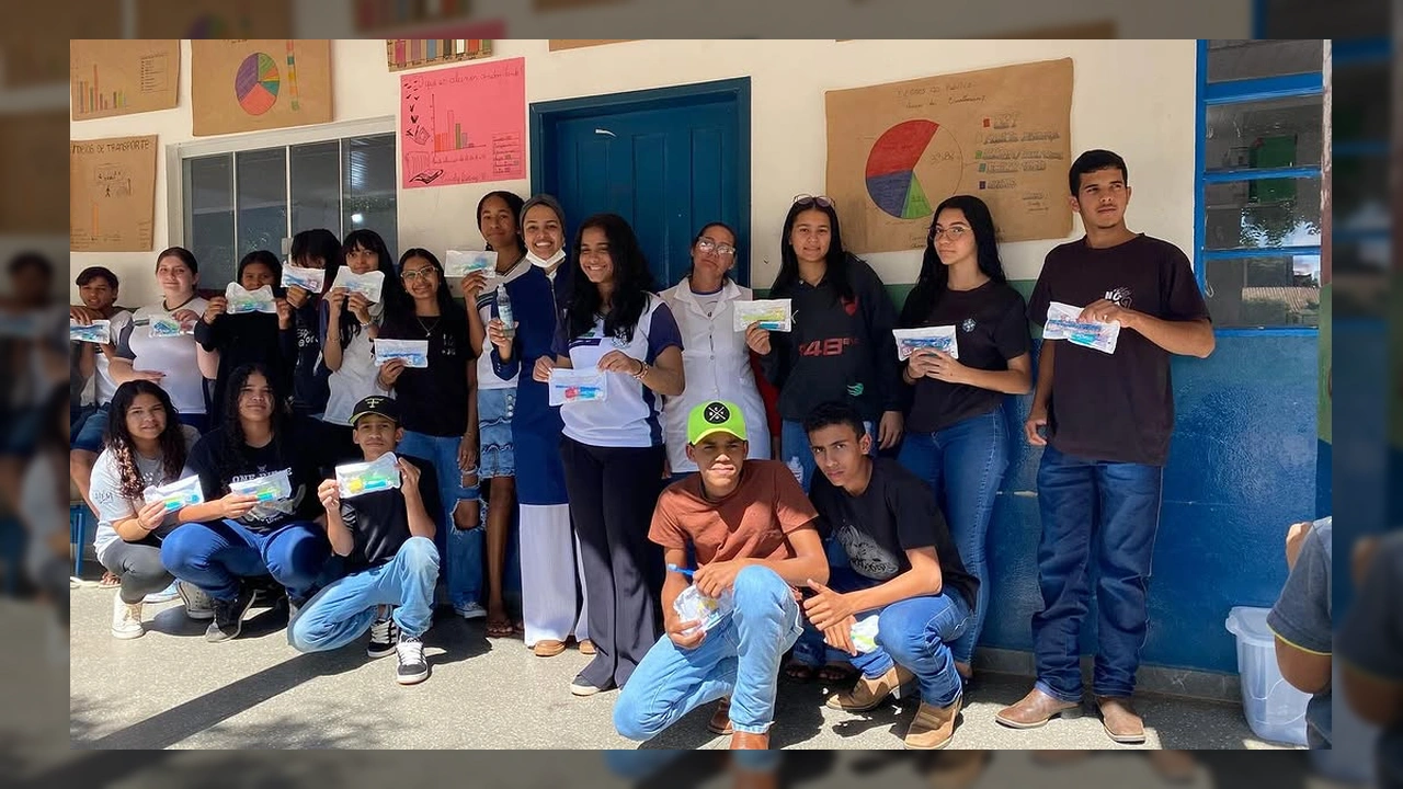 Grupo de alunos e profissionais de saúde sorrindo e segurando kits de higiene bucal na Escola Municipal Jair Aparecido dos Santos, Nova Lacerda / Instagram.