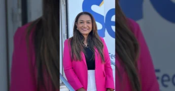 Mulher em frente à Carreta Sesc Saúde Mulher em Diamantino, com os dizeres 'Saúde Mulher' ao fundo. Imagem: Prefeitura de Diamantino / Instagram.