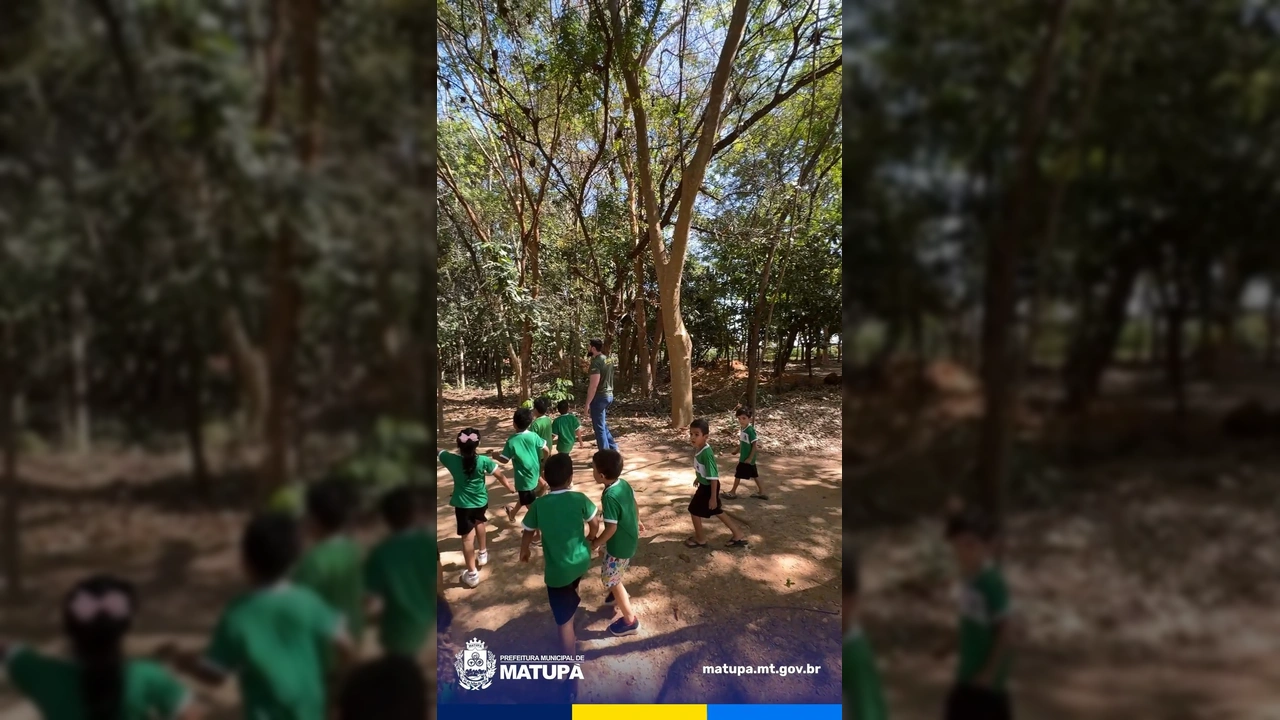 Crianças em uniformes verdes plantando mudas no Viveiro Municipal de Matupá, com adultos da SEMMA orientando. Crédito: Prefeitura Municipal de Matupá / Instagram.