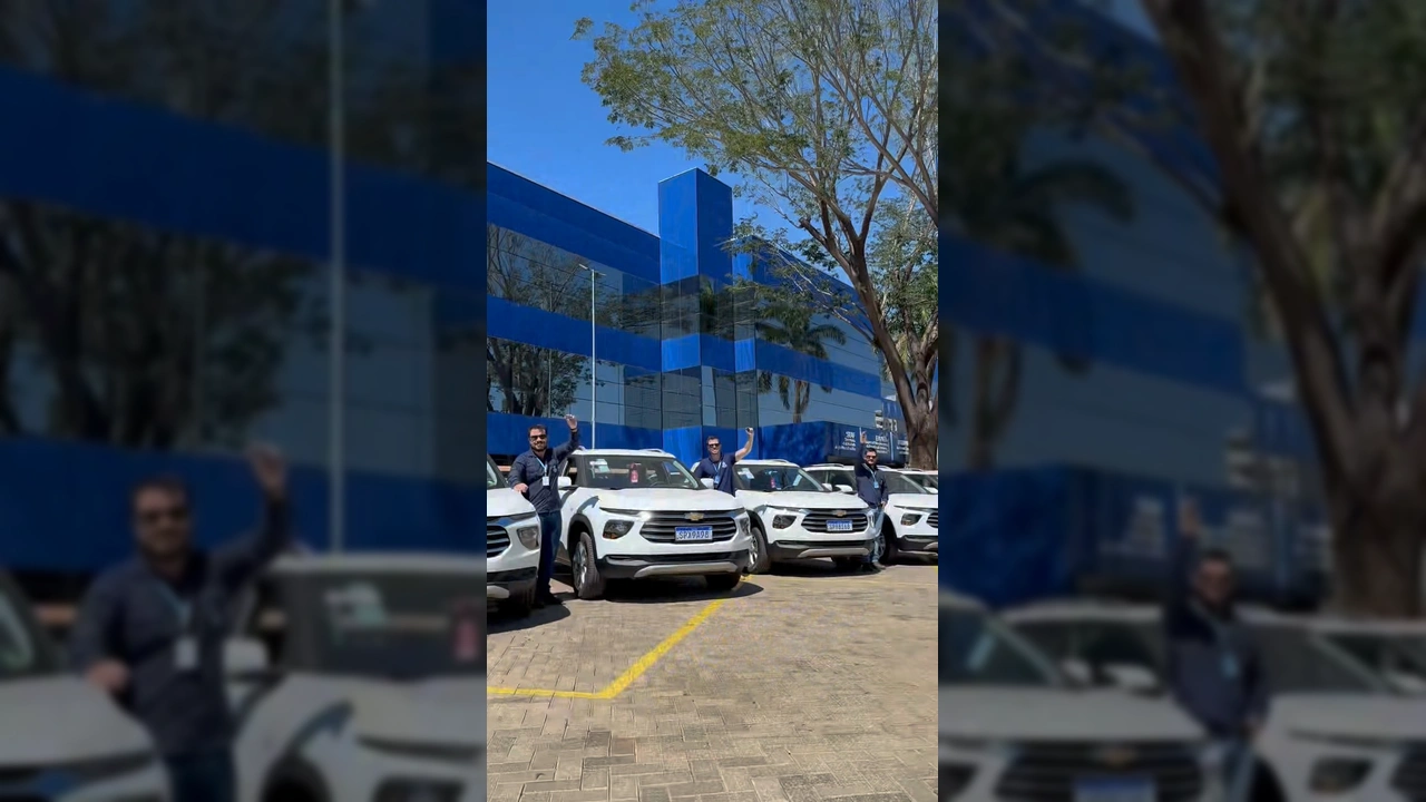 Oito veículos Chevrolet Montana brancos alinhados em frente a um prédio moderno, representando a entrega para a Empaer-MT. Créditos: empaer_mt / Instagram.