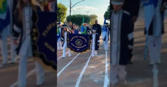 Jovens da Fanfarra Municipal de Nova Bandeirantes em desfile cívico, com bandeiras e instrumentos. Créditos: Prefeitura de Nova Bandeirantes / Instagram.