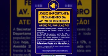 Ilustração de um sino de aviso em um fundo azul e amarelo, com a mensagem 'AVISO IMPORTANTE: FECHAMENTO DA AV. 20 DE DEZEMBRO' em destaque, referente à Primeira Festa da Mandioca em Cotriguaçu. Créditos: Prefeitura Municipal de Cotriguaçu / Instagram