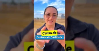 Mulher com óculos e camisa polo preta, falando sobre um curso em Guarantã do Norte com fundo de instalações industriais. / Instagram: @prefeituradeguarantadonorte