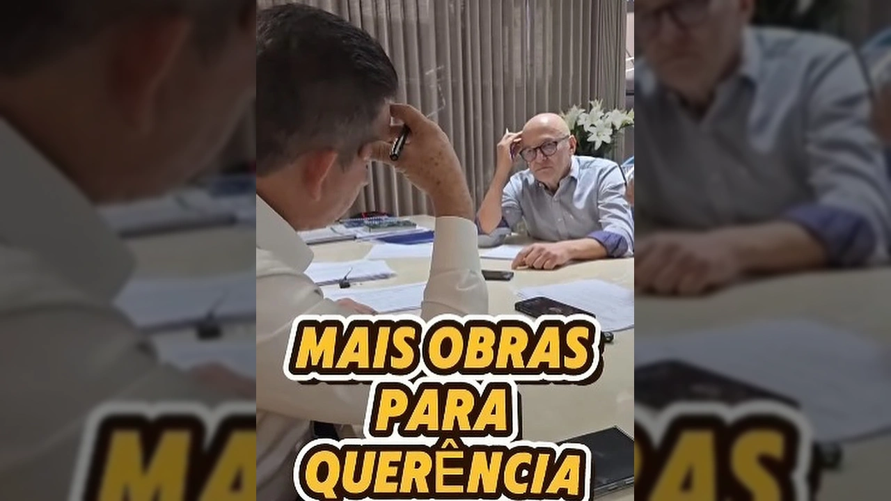 Dois homens em uma mesa de reunião, com a sobreposição de texto 'MAIS OBRAS PARA QUERÊNCIA'. Créditos: Prefeitura de Querência / Instagram.