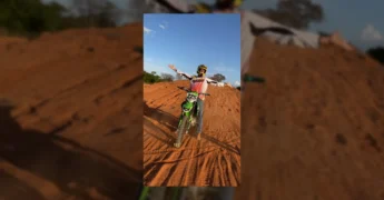 Foto de um piloto de motocross em preto e branco ajustando o capacete antes de uma corrida. Créditos: Prefeitura de Cláudia / Instagram.