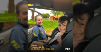 Agente da PRF sorrindo para criança em cadeirinha de carro, promovendo segurança infantil. Créditos: PRF/Instagram.
