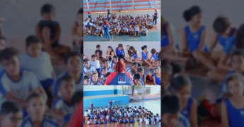 Grupo de crianças e adolescentes sentados no chão, ouvindo uma mulher, em uma quadra, com o logotipo do Projeto Torcida pela Vida no fundo. Crédito: Instagram / prefpoxoreu