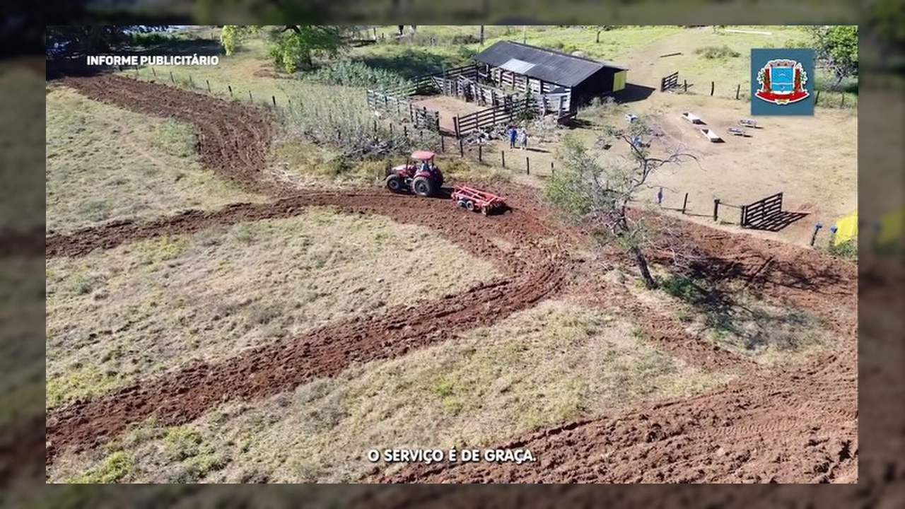 Trator vermelho arando o solo em uma área rural de Jaciara, Mato Grosso, com o implemento de gradagem visível. Crédito: Prefeitura de Jaciara / Instagram.