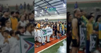 Grupo de atletas de Juara desfilando com a bandeira da cidade durante a abertura dos Jogos Abertos Mato-Grossenses 2025. Crédito: Prefeitura de Juara / Instagram.
