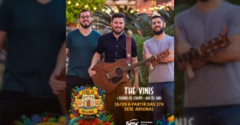 Três músicos da banda The Vinis, um com óculos, outro com violão e o terceiro com baquetas, sorrindo para a câmera durante a Feira do Arsenal no Sesc Cuiabá. Créditos: Sesc Mato Grosso / Instagram.