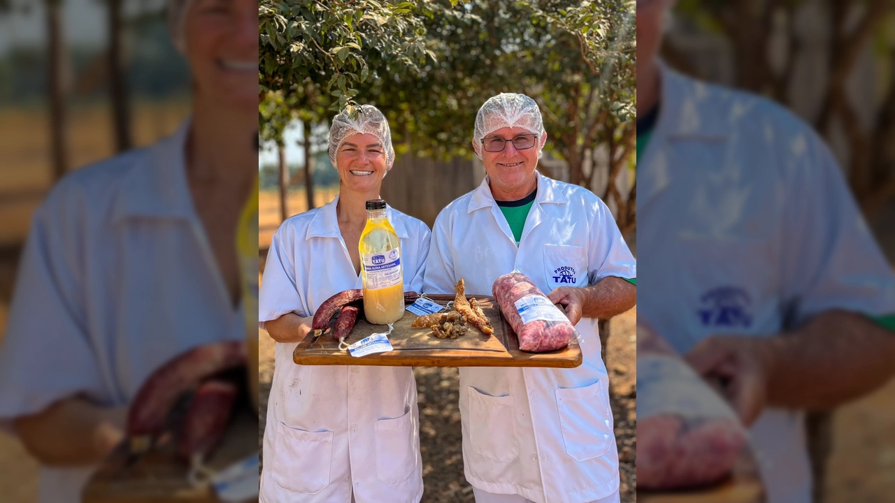 Casal sorridente em Cláudia, Rosane e Otmar, apresentando produtos artesanais com o Selo de Origem, como salame, banha e torresmo / Instagram Prefeitura de Cláudia