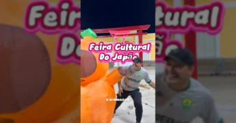 Homem em frente a um totem japonês e um personagem inflável, divulgando a Feira Cultural do Japão em Cuiabá, por Prefeitura de Cuiabá / Instagram