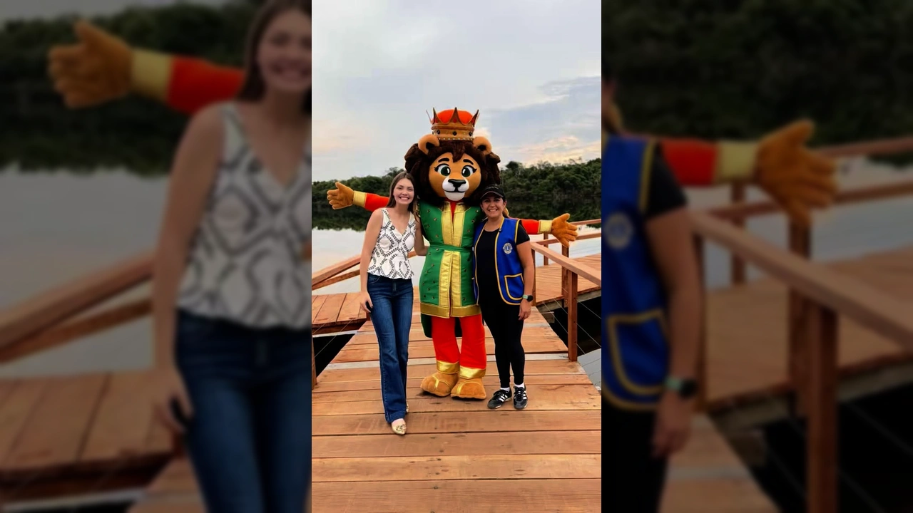 Duas mulheres e o mascote Leão Alegrito em um deck de madeira em Sapezal, promovendo o Festival de Pesca. Créditos: lionssapezal / Instagram