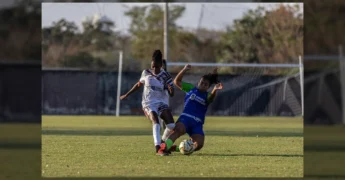 Duas jogadoras de futebol feminino disputam a bola no gramado do CT Carrapicho. Crédito: Nettinho / Instagram fmfmt_oficial