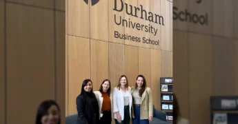 Grupo de quatro mulheres, incluindo representantes da Nova Rota do Oeste, na entrada da Durham University Business School durante o programa InfraLeaders 2025. Créditos: Nova Rota do Oeste / Instagram.