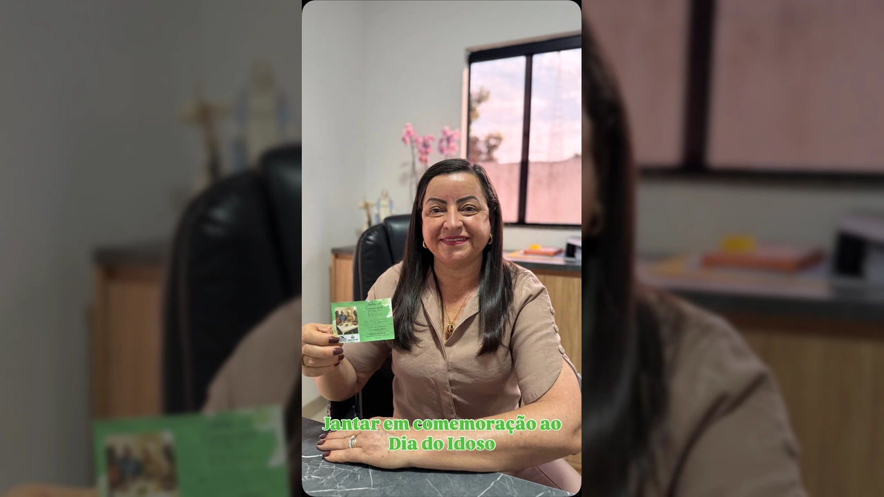 Imagem de uma mulher sorridente segurando um convite verde, em um escritório, convidando para o evento do Dia do Idoso em União do Sul, crédito: Prefeitura Municipal de União do Sul-MT / Instagram.