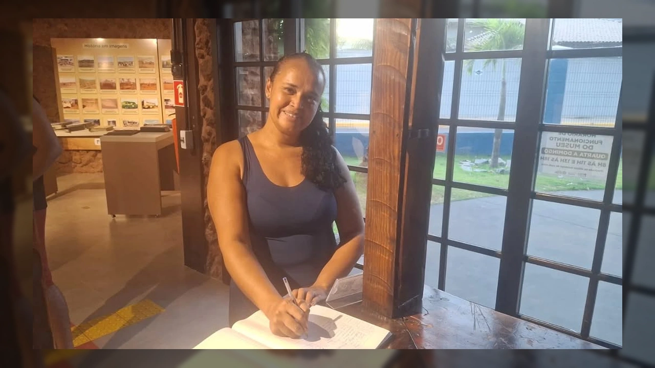 Foto de Cristiane M. Silva Sousa assinando o livro de visitas do Museu Histórico de Lucas do Rio Verde, marcando o recorde de 7.000 visitantes. Créditos: Secretaria de Cultura e Turismo de Lucas do Rio Verde / Instagram