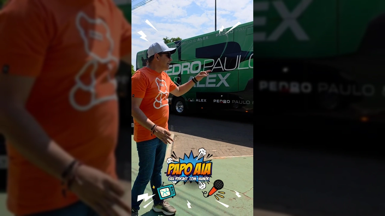 Homem de óculos escuros e boné, sorrindo e gesticulando em frente ao ônibus de turnê da dupla Pedro Paulo & Alex, com o logo do Papo Aia. Créditos para festivalaraguainha / Instagram.