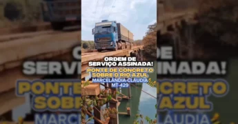 Deputado Dilmar Dal Bosco segurando documento da ordem de serviço para a ponte do Rio Azul na MT-429, com imagens da antiga ponte de madeira. Créditos: Prefeitura de Marcelândia / Instagram