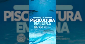 Homem de boné com caderno e homem de chapéu de palha sentado em cadeiras de madeira, com lagoa de piscicultura ao fundo, em Juína, Mato Grosso. Imagem por prefeituradejuina no Instagram.