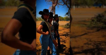 Três mulheres jovens em trajes country, com chapéus de cowboy e faixas de 'Princesa' e 'Rainha do Rodeio', durante a Expo Diamantino 2025. Imagem via expodiamantino.