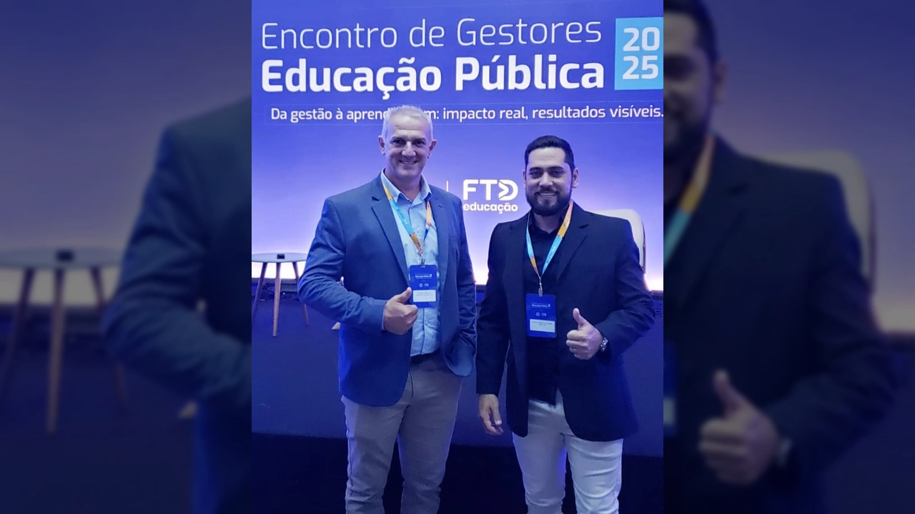 Dois homens sorrindo e fazendo sinal de positivo, em frente a um banner do 'Encontro de Gestores Educação Pública 2025' em Cuiabá. Créditos: Instagram @terranovadonorte